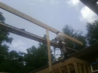 Carpenter setting a ridge beam over a new addition frame — Ice Dam Removal by Roofing Brothers in Dixon