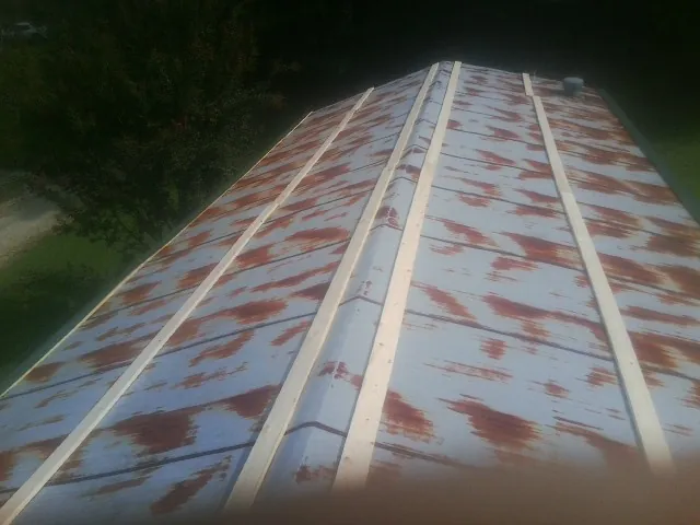 Rusted metal roof panels with new wood purlins before replacement — Storm Damage Roof Repair in Dixon by Roofing Brothers